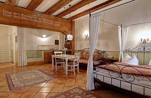 ein Schlafzimmer mit einem Bett und einem Tisch darin in der Unterkunft Hotel Orphée Andreasstadel in Regensburg