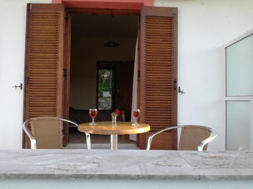 a table with two glasses of wine on a patio at Tony studio & apartments in Laganas