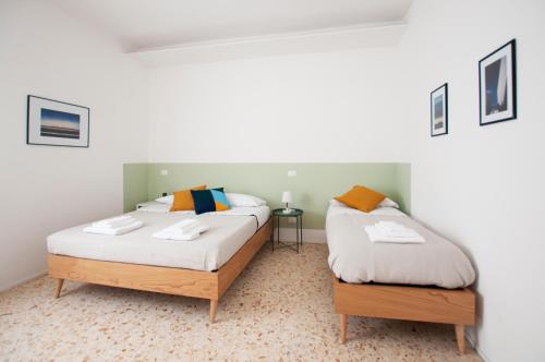 two twin beds in a room with acknowled at Casa27 Affittacamere in Terracina