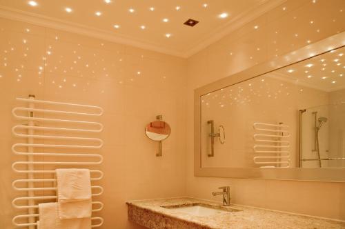 a bathroom with a sink and a large mirror at Hotel Arabell in Lech am Arlberg