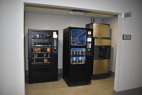 two soda machines in a room next to a refrigerator at Country Inn & Suites by Radisson, Hagerstown, MD in Hagerstown