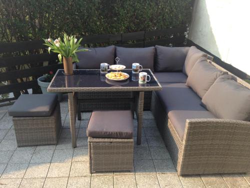 a couch and a table with a plate of food on it at Westerschelde B&B in Vlissingen
