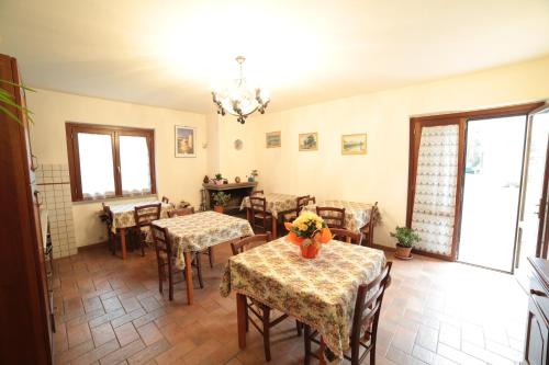 a dining room with tables and chairs and a chandelier at Agriturismo La Piantata in Bolsena