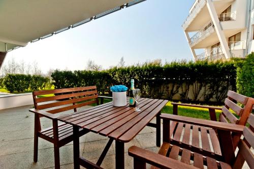 a wooden table and two benches sitting on a patio at BlueApart Apartamenty Na Klifie in Władysławowo