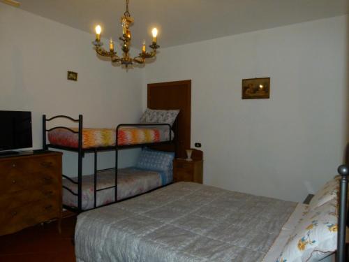 a bedroom with a bed and a chair and a chandelier at B&B La Poiana in Urbino