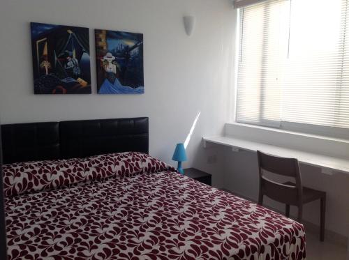 a bedroom with a red bed and a window at 8villa in St Julian's