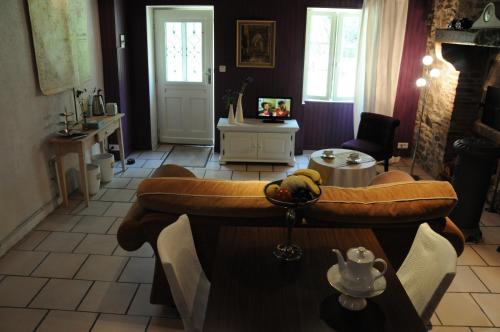 un salon avec un canapé et une table dans l'établissement B&B Maison Coralie, à Sainte-Christine