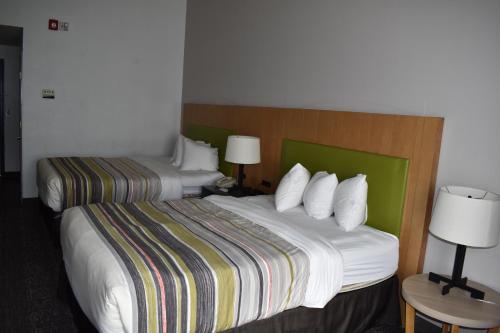 a hotel room with two beds and two lamps at Country Inn & Suites by Radisson, Hagerstown, MD in Hagerstown