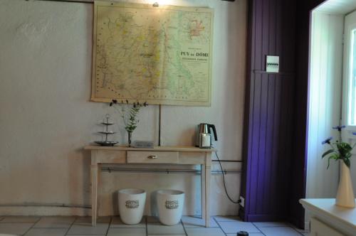 una habitación con una mesa con un mapa en la pared en B&B Maison Coralie, en Sainte-Christine