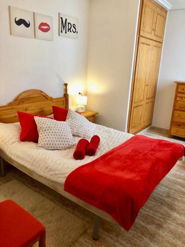 a bedroom with a bed with red shoes on it at Fresa Apartaments in La Mata