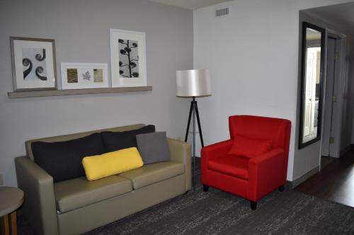a living room with a couch and a red chair at Country Inn & Suites by Radisson, Hagerstown, MD in Hagerstown