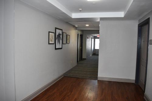 a hallway with white walls and wood floors and pictures at Country Inn & Suites by Radisson, Hagerstown, MD in Hagerstown