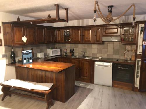 cocina con armarios de madera y encimera de madera en Les Chemines, en La Thuile