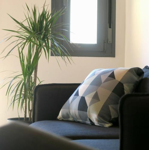a couch with a pillow and two plants in a room at Apartamento Zocailla Suite in Gata