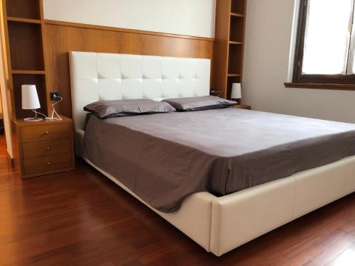 a large white bed with a white headboard in a bedroom at Veneto Civico 17 in Sarnico