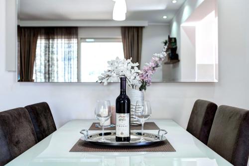 コトルにあるEdiLuxのワイン1本とグラスをテーブルに用意しています。