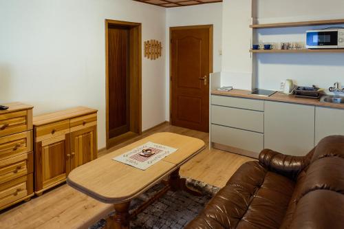 a living room with a couch and a table in a kitchen at Apartmány Hrady in Zuberec