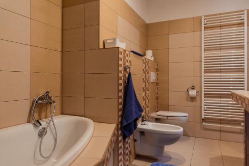 a bathroom with a tub and a toilet and a sink at Apartmány Hrady in Zuberec