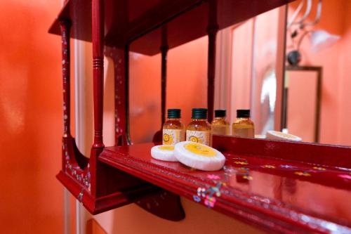 a red shelf with bottles of honey and a mirror at Casa del Loggiato in Cortona
