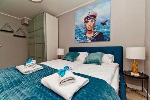 a bedroom with a blue bed with towels on it at Villa Aqua BlueApart Jurata in Jurata