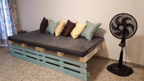 a couch made out of a pallet with a fan at Habitación Independiente Sur - Cali in Cali