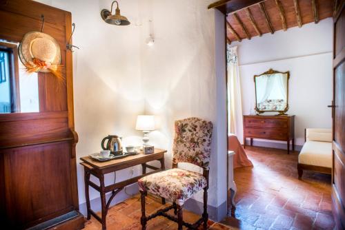 a living room with a chair and a table at Agriturismo Pieve Sprenna in Buonconvento