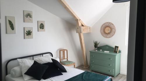 - une chambre avec un lit et une commode verte dans l'établissement le gite de Jules, à Azay-le-Rideau
