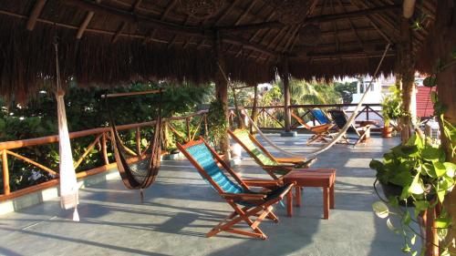 a group of chairs and hammocks on a porch at Casa Almendro in Tulum