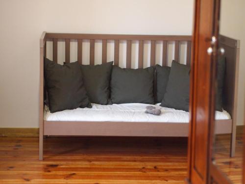 a bed with gray pillows and a stuffed animal on it at Casa da Tia Dulce in Pataias