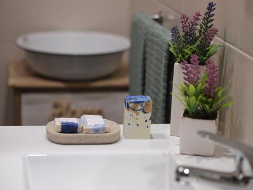 a counter with two containers of soap and flowers on it at Casa da Tia Dulce in Pataias