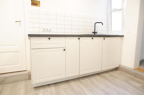 a kitchen with white cabinets and a sink at Apartment Zentral in Tübingen