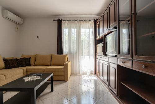 a living room with a couch and a tv at Guesthouse Drašković in Petrovac na Moru