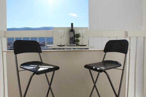 zwei schwarze und weiße Stühle an einer Küchentheke in der Unterkunft Full View in Mostar