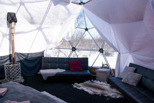 a living room with a couch in a tent at Aurora Dome in Kiruna
