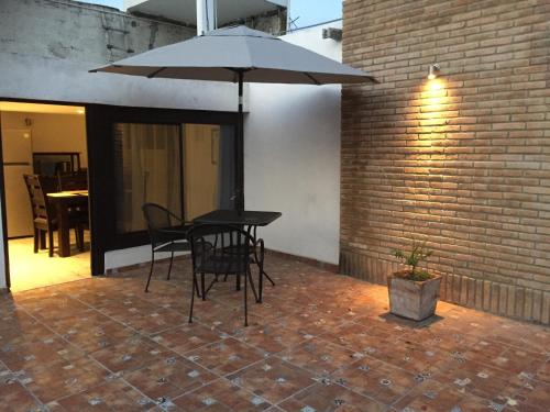 a table and chairs under an umbrella on a patio at Mi Depa Vainilla en pleno Centro de la Ciudad in Ciudad Valles