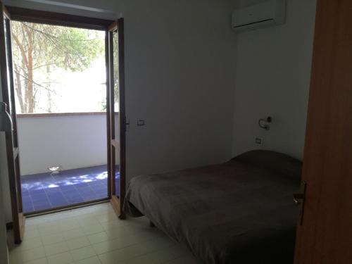 ein Schlafzimmer mit einem Bett und einem großen Fenster in der Unterkunft Villetta Medusa in Copanello