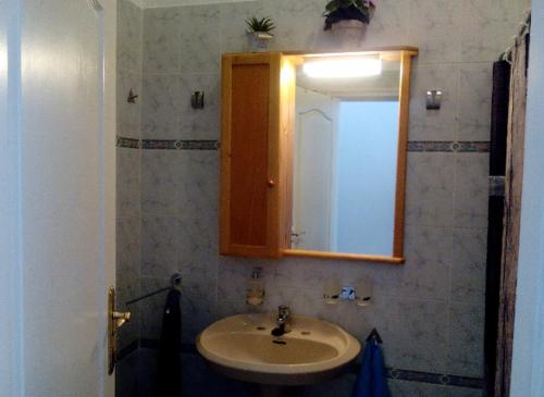 a bathroom with a sink and a mirror at A cozy flat in the heart of El Fraile in Las Galletas