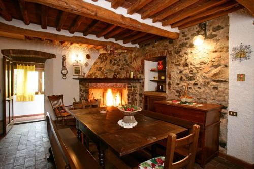 sala de estar con mesa de madera y chimenea en Villa Giulia a "Casa Conti di Sotto", en Gavorrano