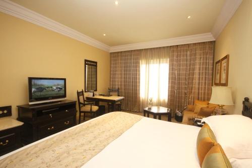 a hotel room with a bed and a television at Taj Bengal in Kolkata
