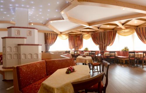 restauracja ze stołami i krzesłami w pokoju w obiekcie Hotel Dalla Serra w mieście Mezzana