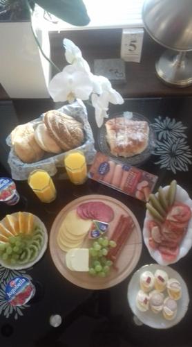 a table topped with plates of food and drinks at Apartament wSPAniały. in Kowary