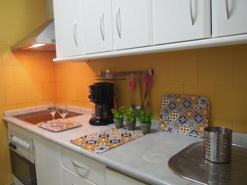 a kitchen with a counter top with two plates and glasses at Apartamento San Anton in Granada