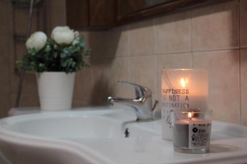 a candle on a sink with a vase of flowers at Salt Lake Town House in Larnaca