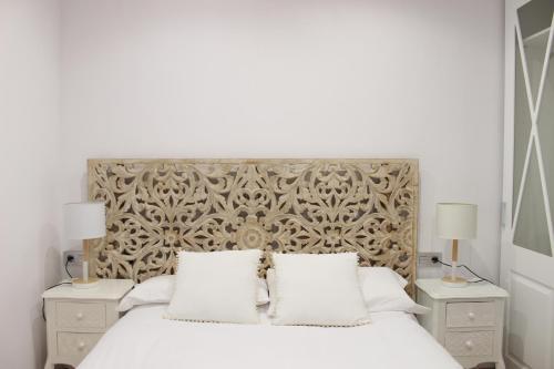 um quarto com uma grande cama branca com duas mesas de cabeceira em Morente sueña La Alhambra em Granada