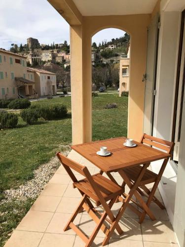 a wooden table and chairs sitting on a porch at La Tour de Guet in Montbrun-les-Bains