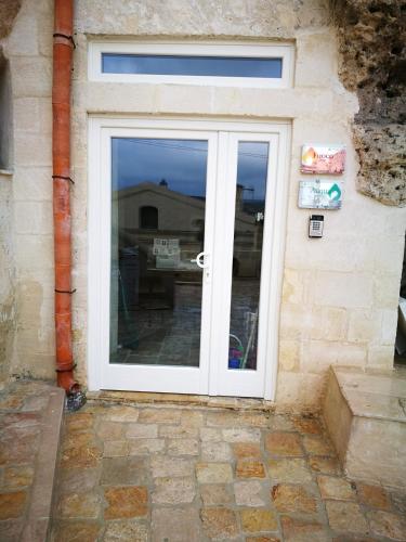 a white door with a window on a building at 5 Elementi Sassi Matera in Matera