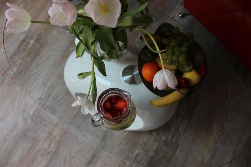 un vase rempli de fruits et de fleurs sur une table dans l'établissement Romantický wellness suite hotel Heinz, à Dobříš