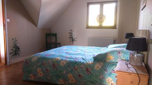 a bedroom with a bed with a colorful blanket at La maison de Keralies in Pleumeur-Bodou
