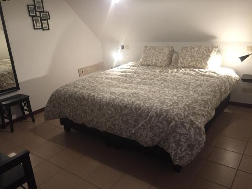 a bedroom with a large bed with two pillows at Gastenverblijf 't Hof van Eden in Wingene