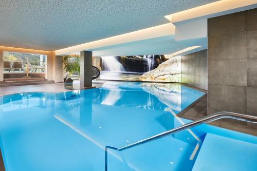 uma piscina numa casa com cascata em Hotel Post am See em Pertisau